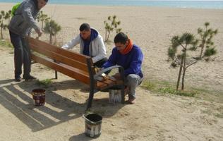 alumnes del PTT de fusteria pinten el mobiliari de les platges